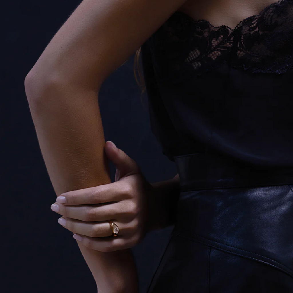 Bague femme en or avec pierre brillante portée à la main, style luxe et élégant avec tenue habillée