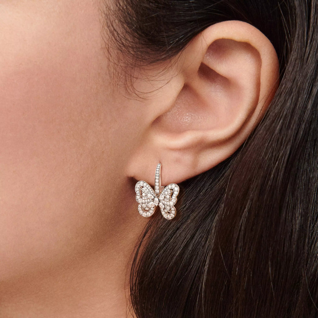 Boucles d’oreilles femme en forme de papillon avec pierres brillantes en zirconium portées à l’oreille, style élégant et raffiné