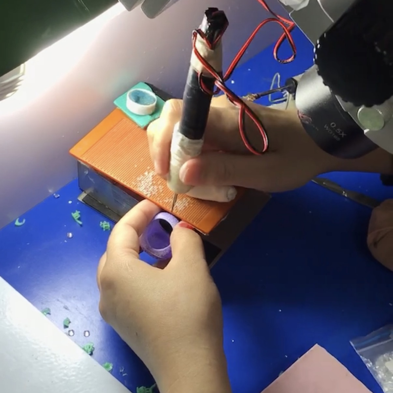 Main en train de graver une bague sur mesure avec outil de précision en atelier, fabrication artisanale de bijou