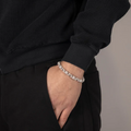 Bracelet perlé en argent avec zirconium porté au poignet d’un homme, design moderne et élégant