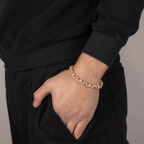 Bracelet perlé rose gold avec détails zirconium porté au poignet d’un homme, style tendance et élégant
