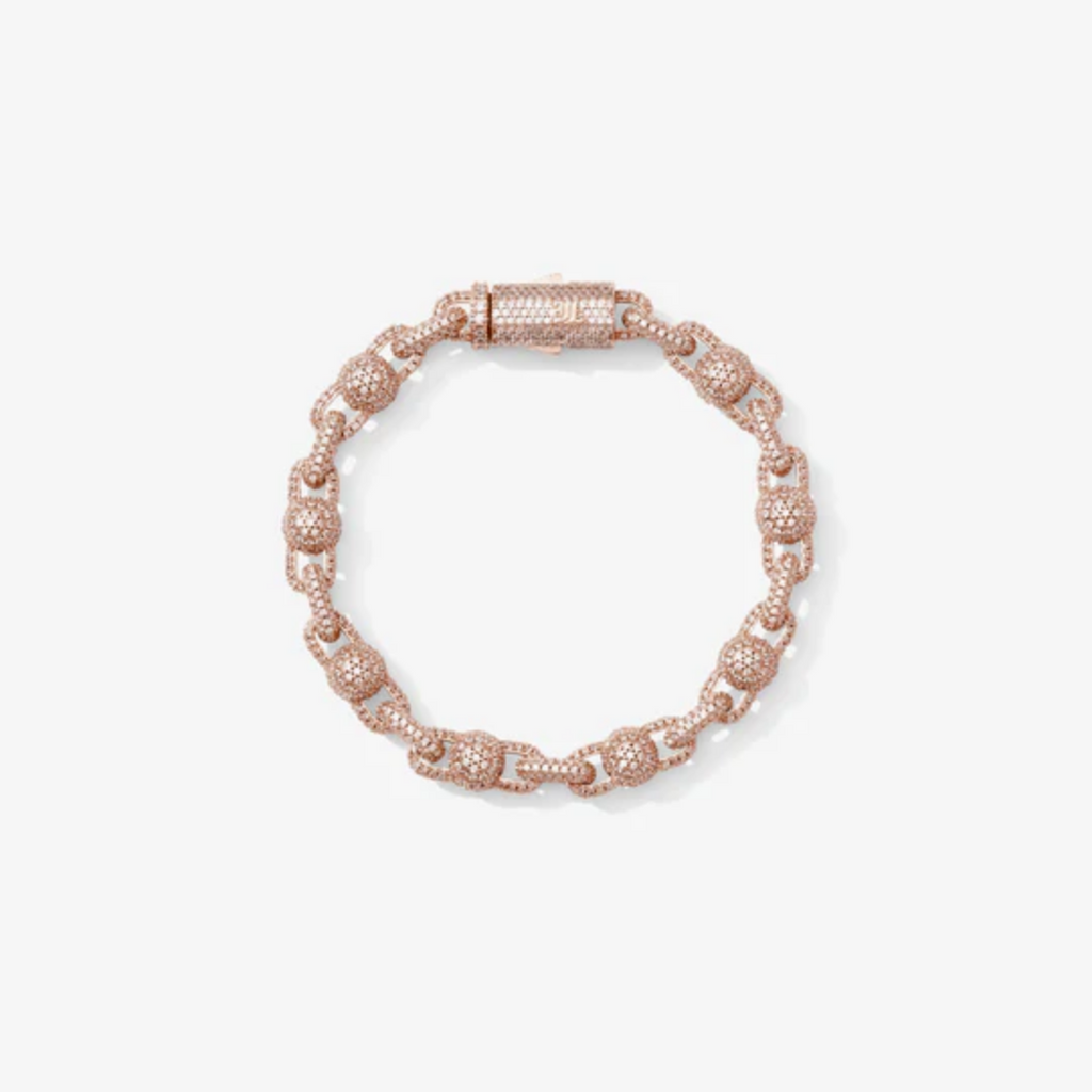 Bracelet perlé rose gold avec détails zirconium porté au poignet d’un homme, style tendance et élégant