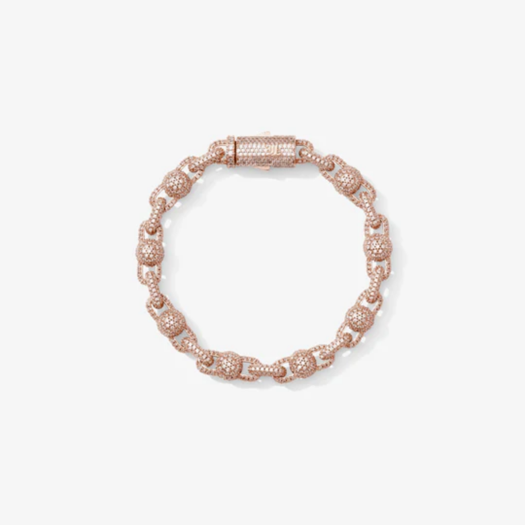 Bracelet perlé rose gold avec détails zirconium porté au poignet d’un homme, style tendance et élégant