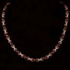 Collier perlé rose gold porté par un homme avec boucles d’oreilles, style tendance et moderne