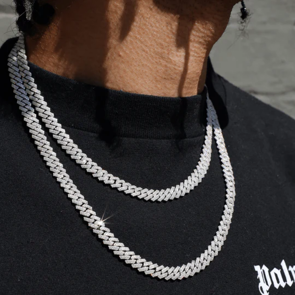 Deux colliers chaîne en argent portés en superposition par un homme, style luxueux et moderne