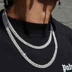 Deux colliers chaîne en argent portés en superposition par un homme, style luxueux et moderne